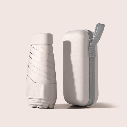 Mini capsule umbrella next to its zipped carry case