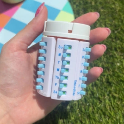 Several pill trackers stuck on one bottle, held in hand